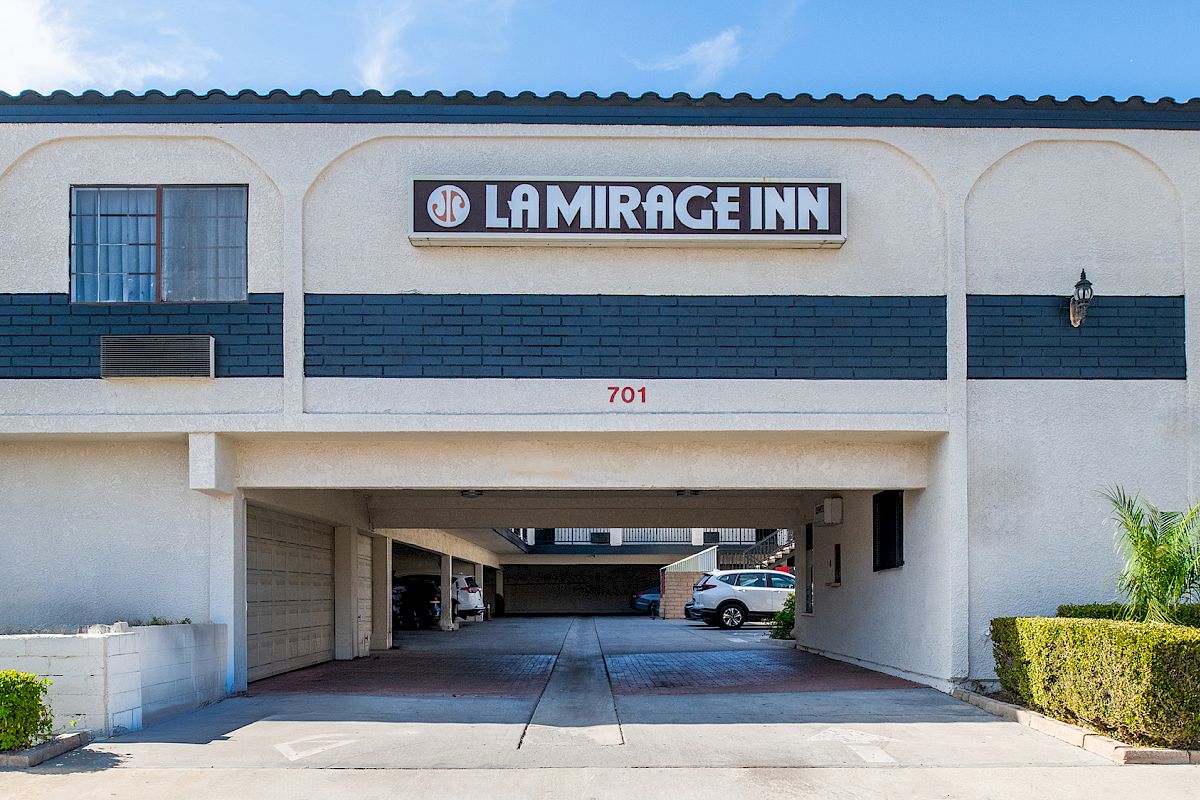 The image shows the entrance to a building labeled "La Mirage Inn," with a driveway and some parking spaces visible underneath.