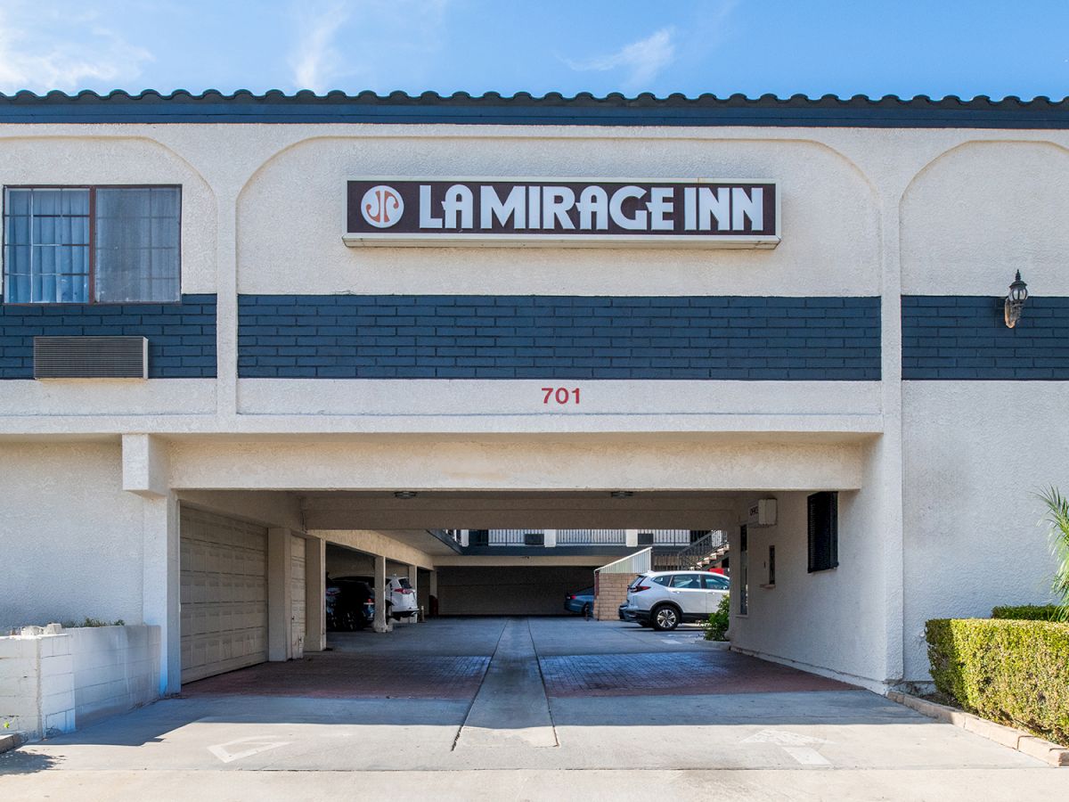 The image shows the entrance to a building labeled "La Mirage Inn," with a driveway and some parking spaces visible underneath.