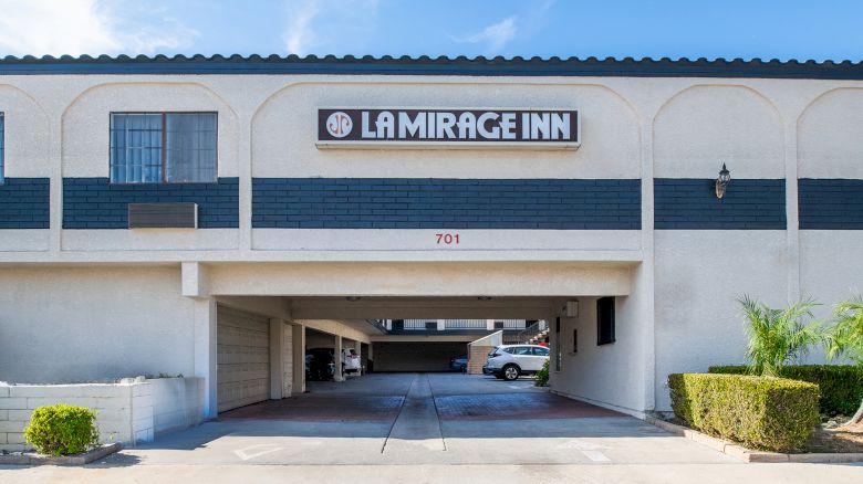 The image shows the entrance to a building labeled "La Mirage Inn," with a driveway and some parking spaces visible underneath.