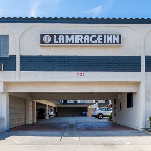 The image shows the entrance of a building labeled "La Mirage Inn" with a number 701 above the parking area. 