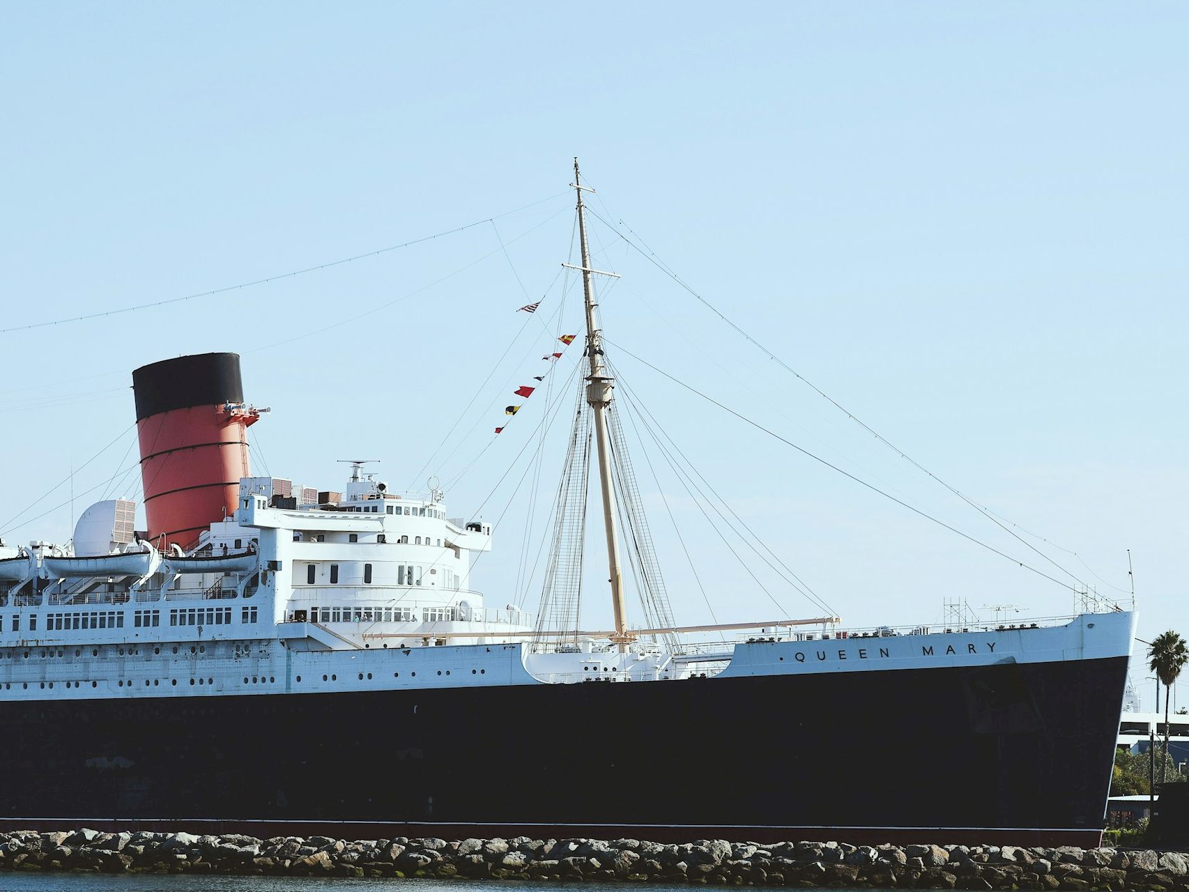 a large white and black ship with a red funnel