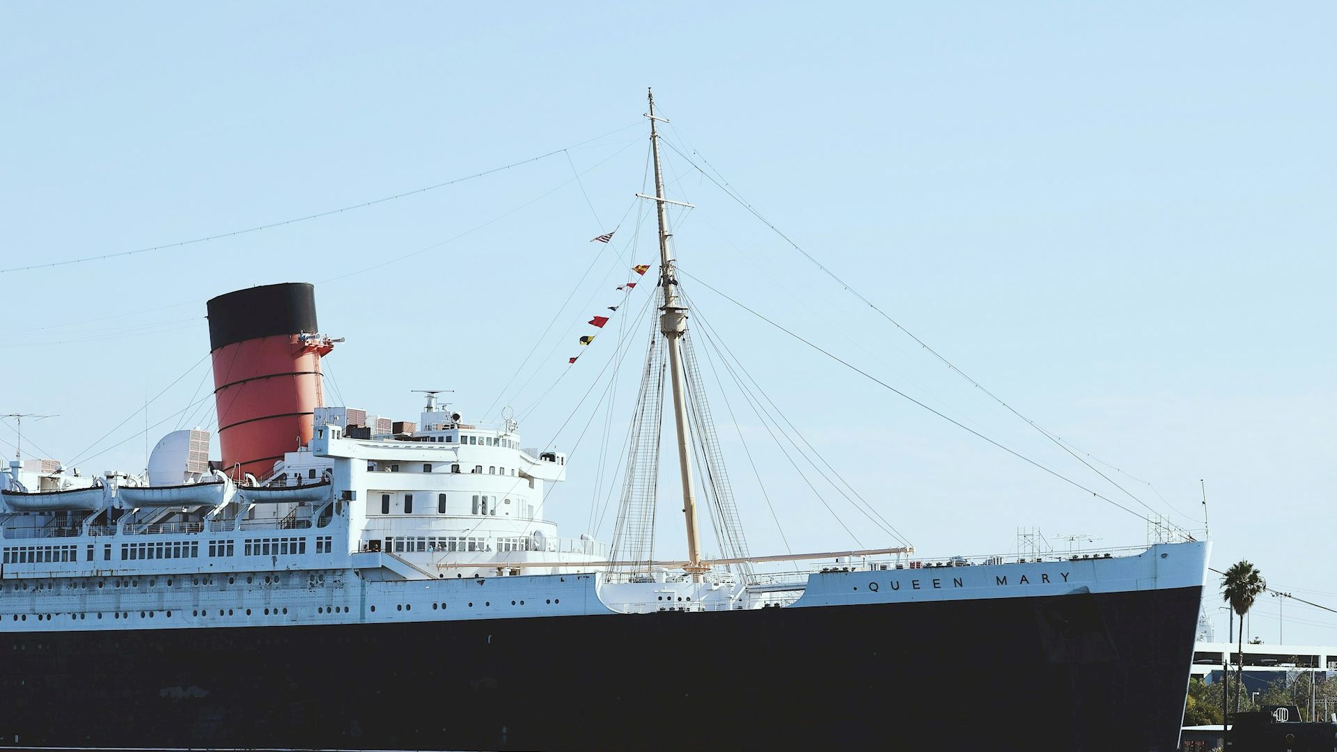 A large ocean liner with the name Queen Mary on the side