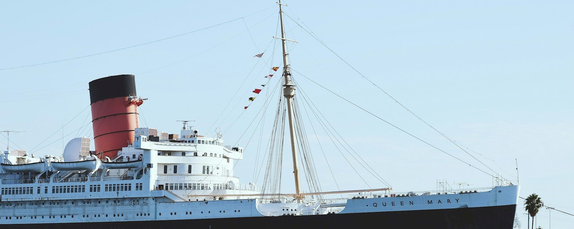a large white and black ship with a red smokestackon