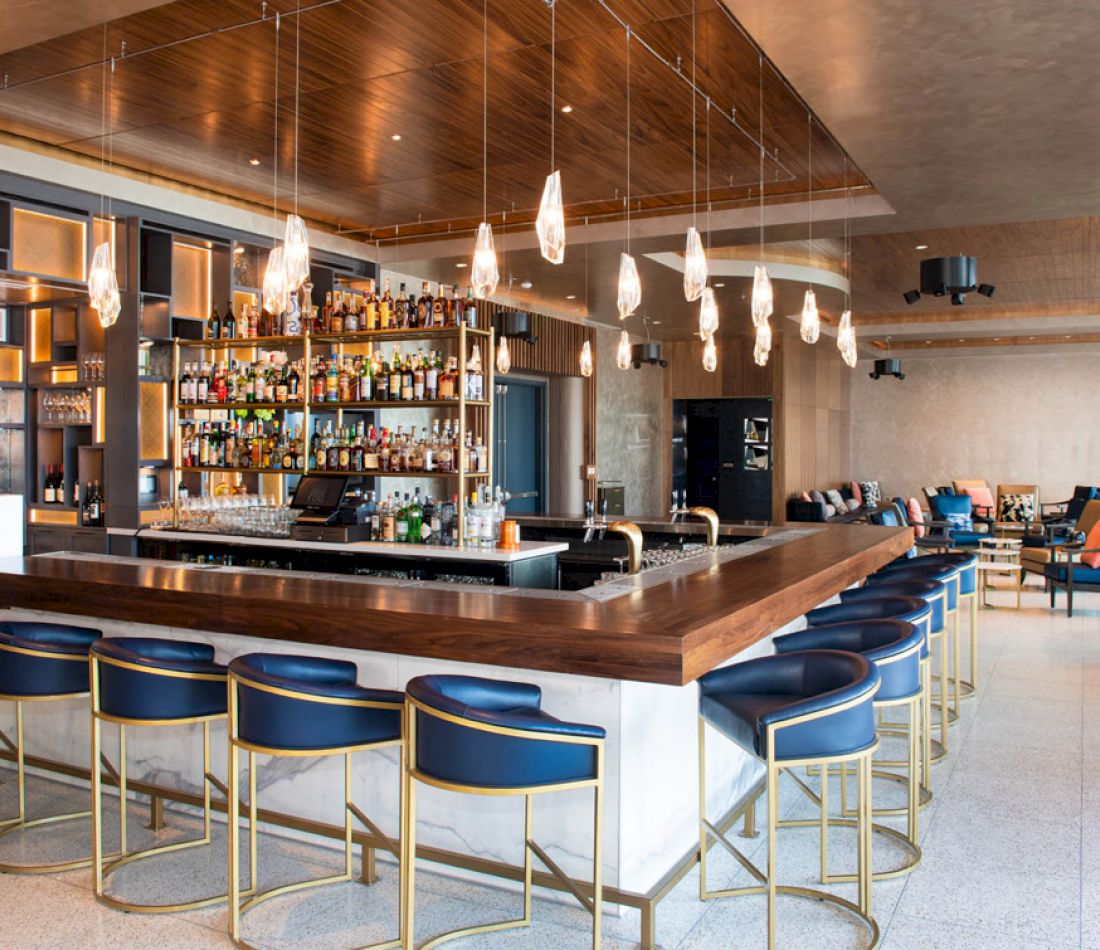 a bar with blue stools and a wooden counter